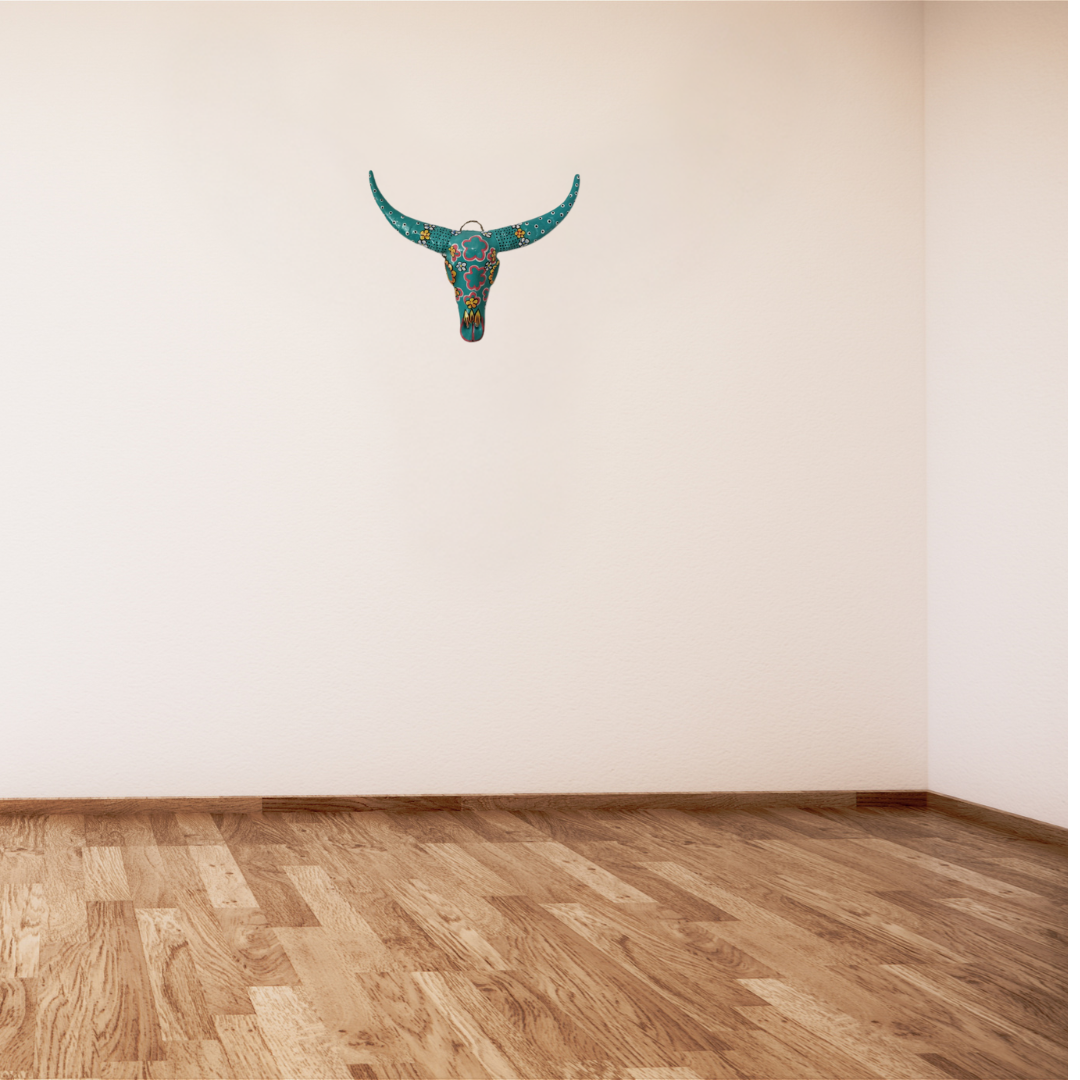 Handcrafted Floral Resin Bull Skull in Turquoise mounted on a white wall above timber hardwood flooring, showcasing the true scale and wall display of this bohemian statement piece, 45cm x 25cm wall art by Azure Decor