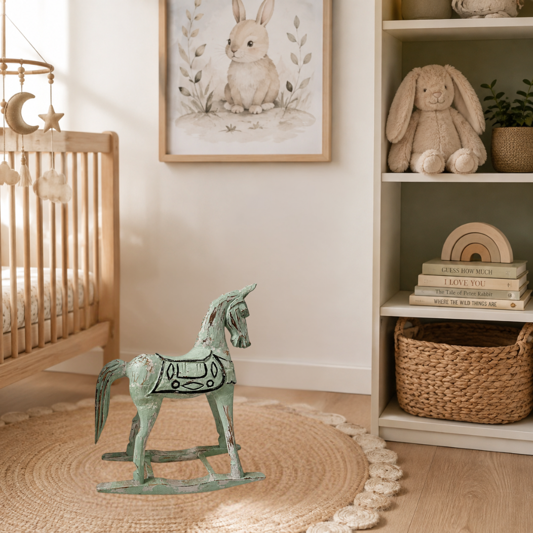 Sage green rocking horse decor with a  distressed timber on a jute rug in a Scandinavian-style baby nursery beside a wooden cot