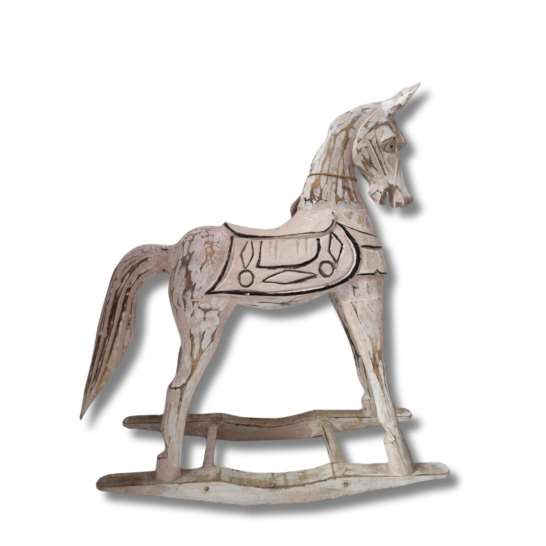 Full side profile of a distressed white timber art with carved saddle and curved rocker base