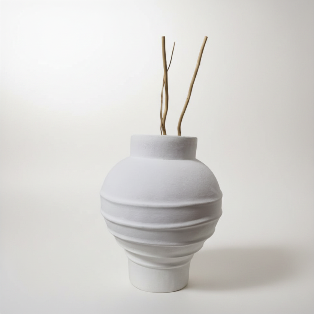 White ceramic vase with textured design on a white background