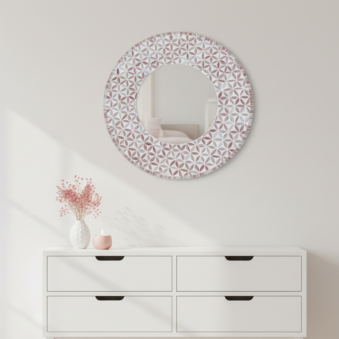 Pink mosaic mirror above white dresser with dried flowers in blush coastal bedroom
