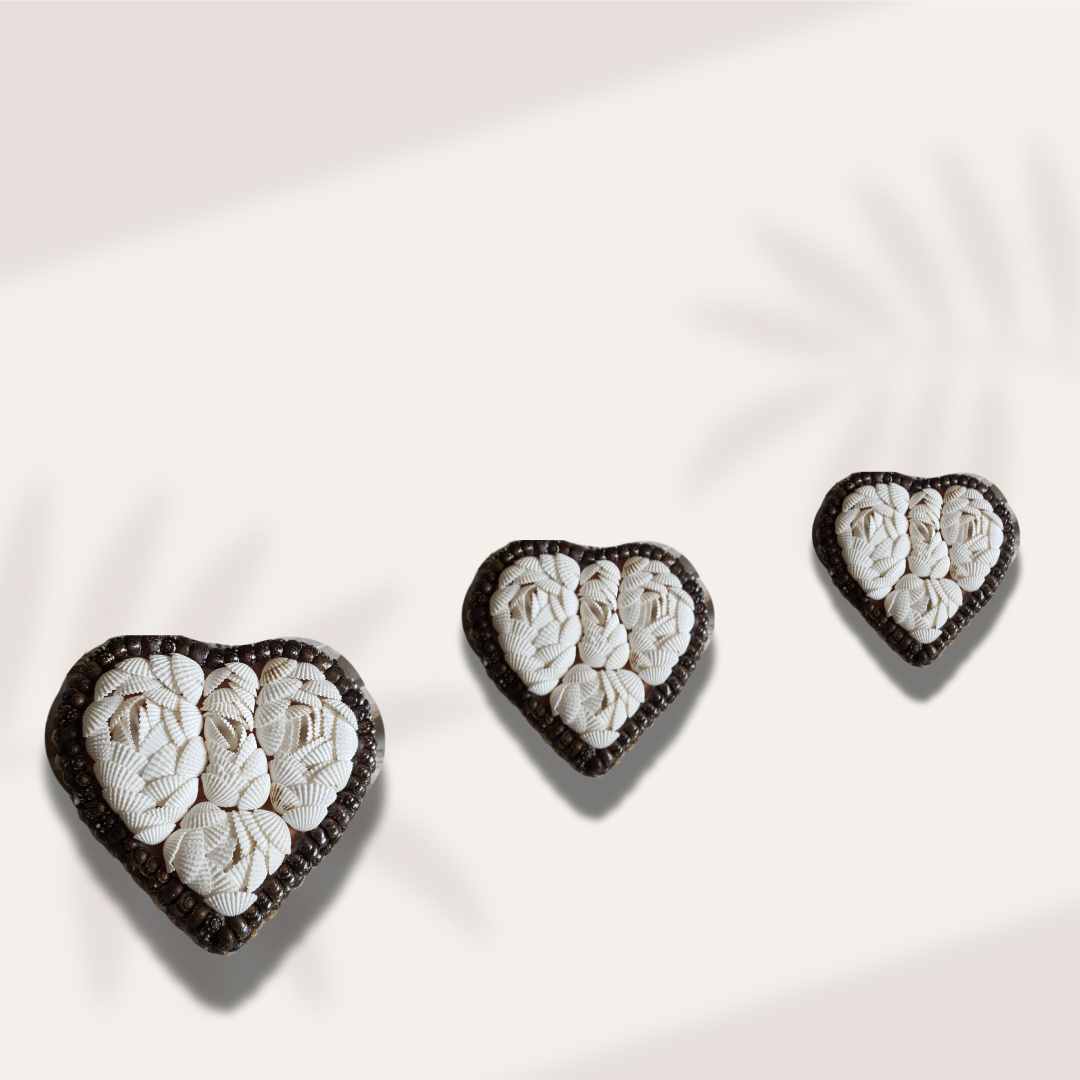 heart shaped trinket box with a black interior and a white shell-covered lid finished with dark beaded trim.