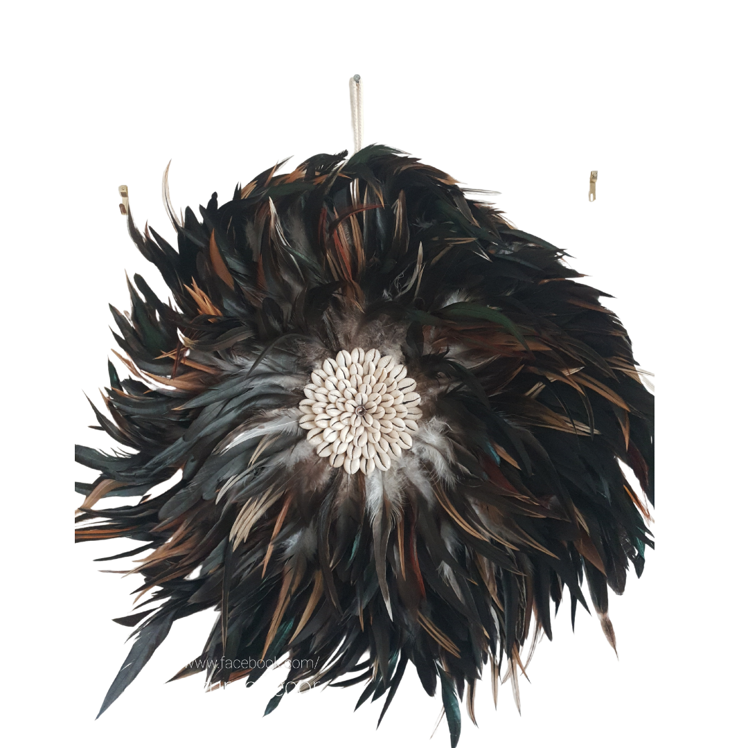 Handcrafted Balinese Juju Hat wall hanging featuring layered dark feathers with a cowrie shell centre. Boho-inspired wall décor measuring 40–50cm, perfect for adding texture and natural coastal style to any room.