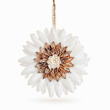 White feather juju hat wall hanging with orange and brown shell flower centre