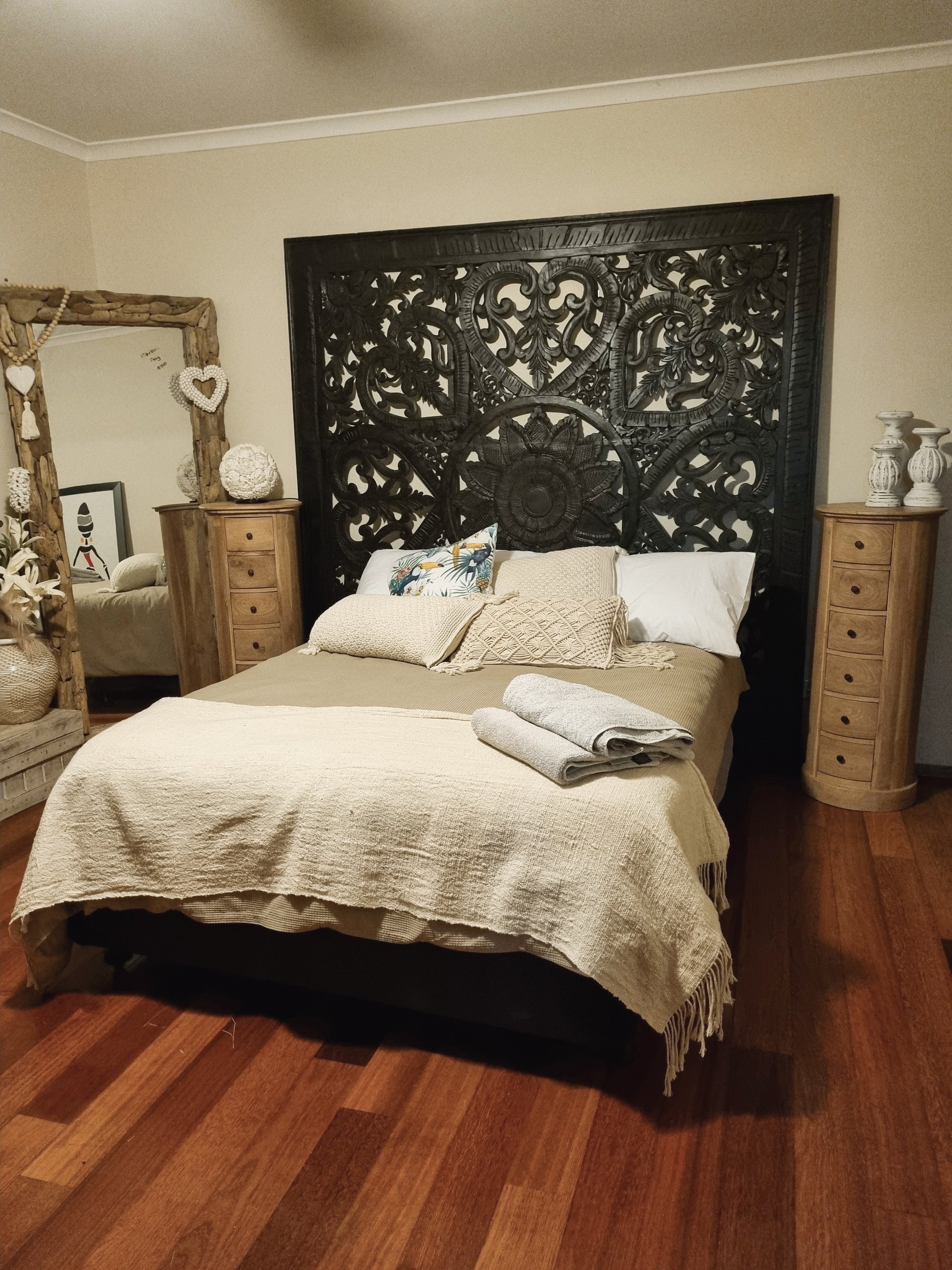 Bedroom with a large ornate headboard and wooden floor.