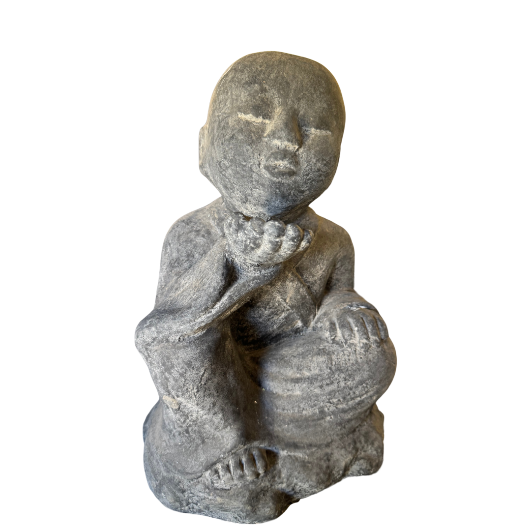 A small gray stone figurine of a seated child with a weathered, rustic texture, isolated on a white background.