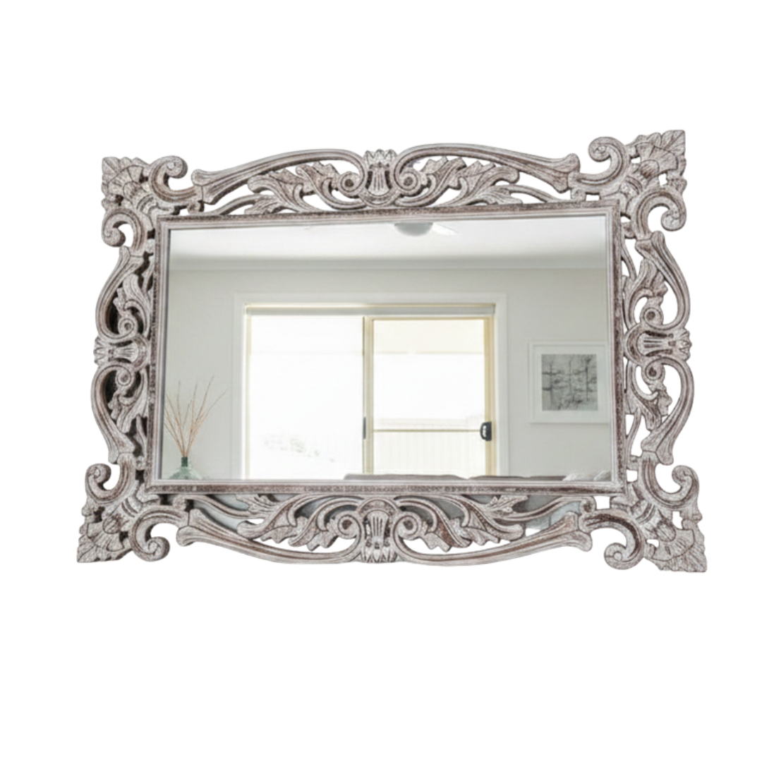 Decorative wall mirror with intricate silver frame on a white background