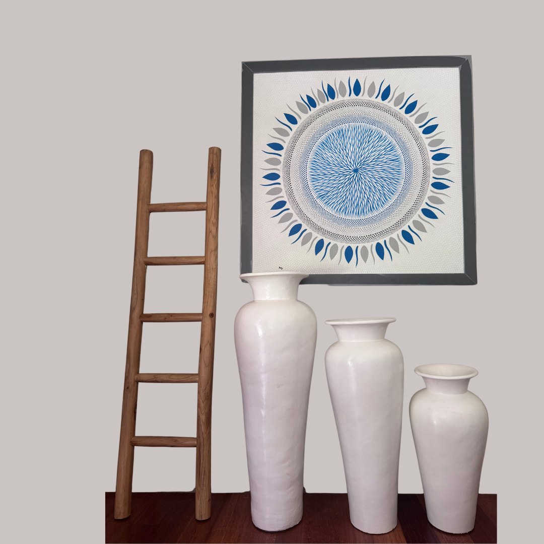 Decorative wall art with a circular design, white vases, and a wooden ladder against a plain wall.