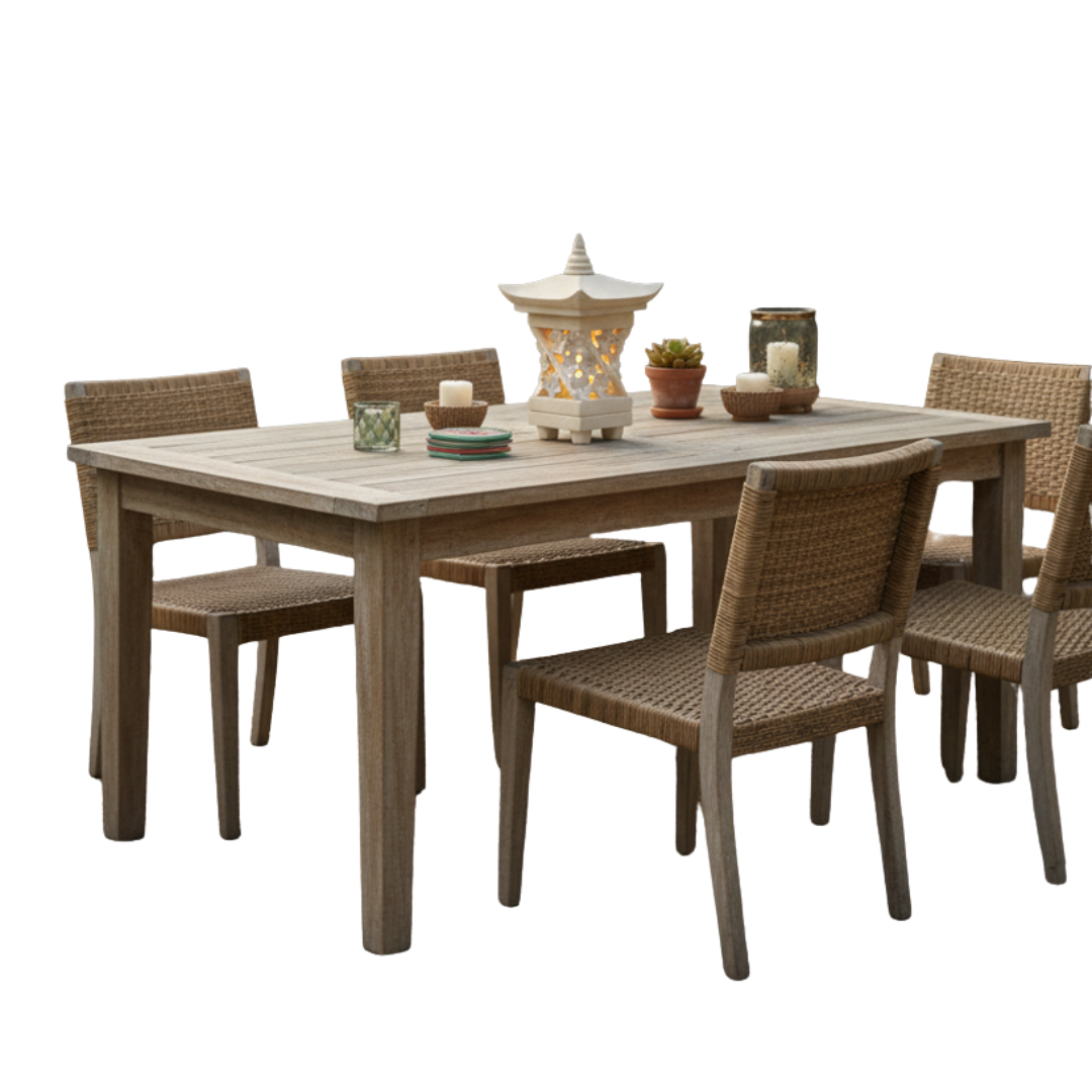 Handcrafted stone centrepiece on a teak outdoor dining table with wicker chairs and garden styling