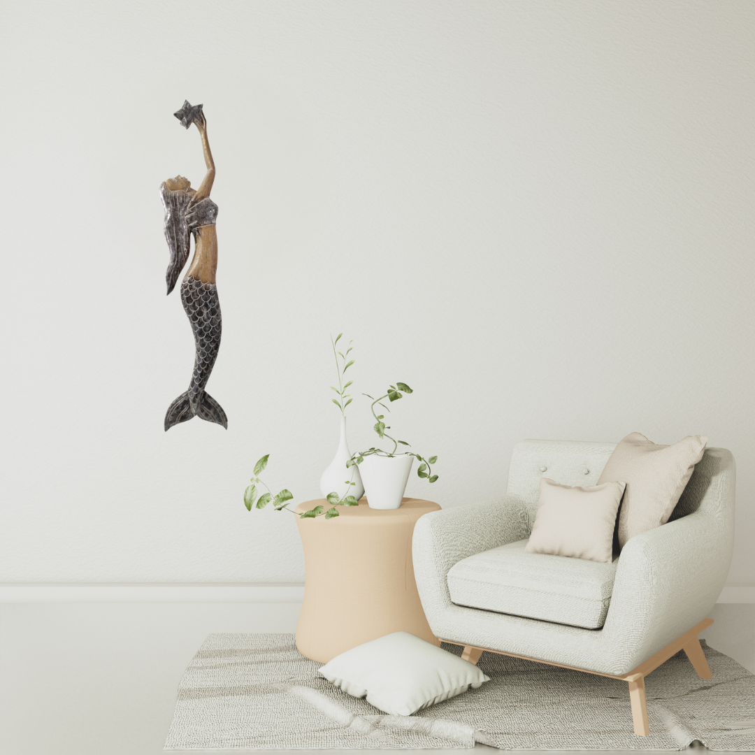 Decorative mermaid wall art above a modern armchair with a small table and plant in a minimalistic room.