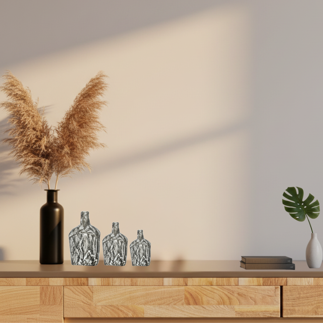 Three handcrafted black timber bottle decor pieces on a timber bookshelf with trailing pothos plant and neutral linen books — modern Australian living room decor