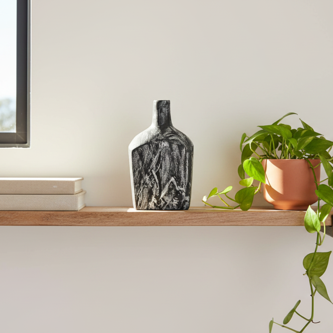 Handcrafted medium black timber bottle decor with white carved grain detail styled on a white marble bathroom vanity with pillar candle and eucalyptus — 25 x 12cm