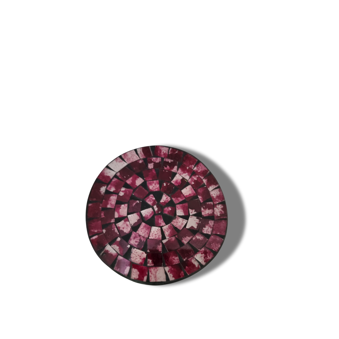 Close-up top-down view of a round with deep plum and burgundy tile pattern radiating from the centre