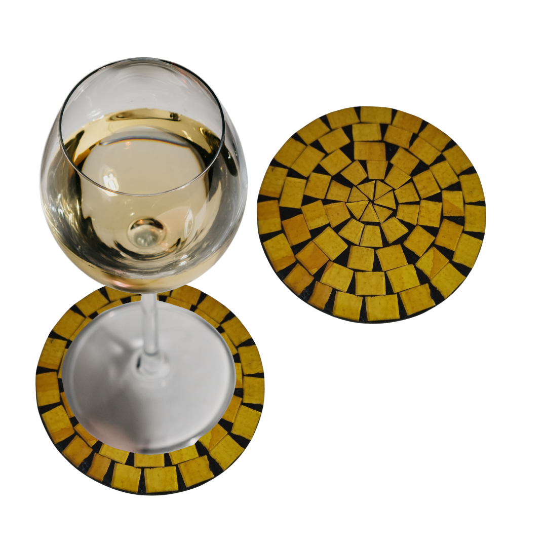 Two yellow with golden yellow tile spiral pattern on a black base, one with a white wine glass resting on it