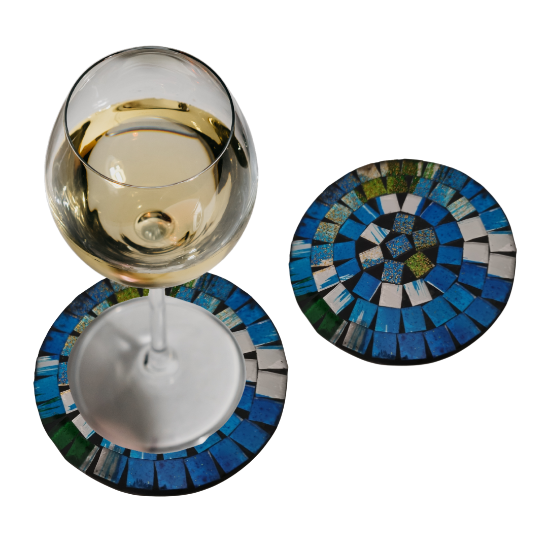 Two  with ocean blue, teal, green and white tile pattern, one with a white wine glass resting on it