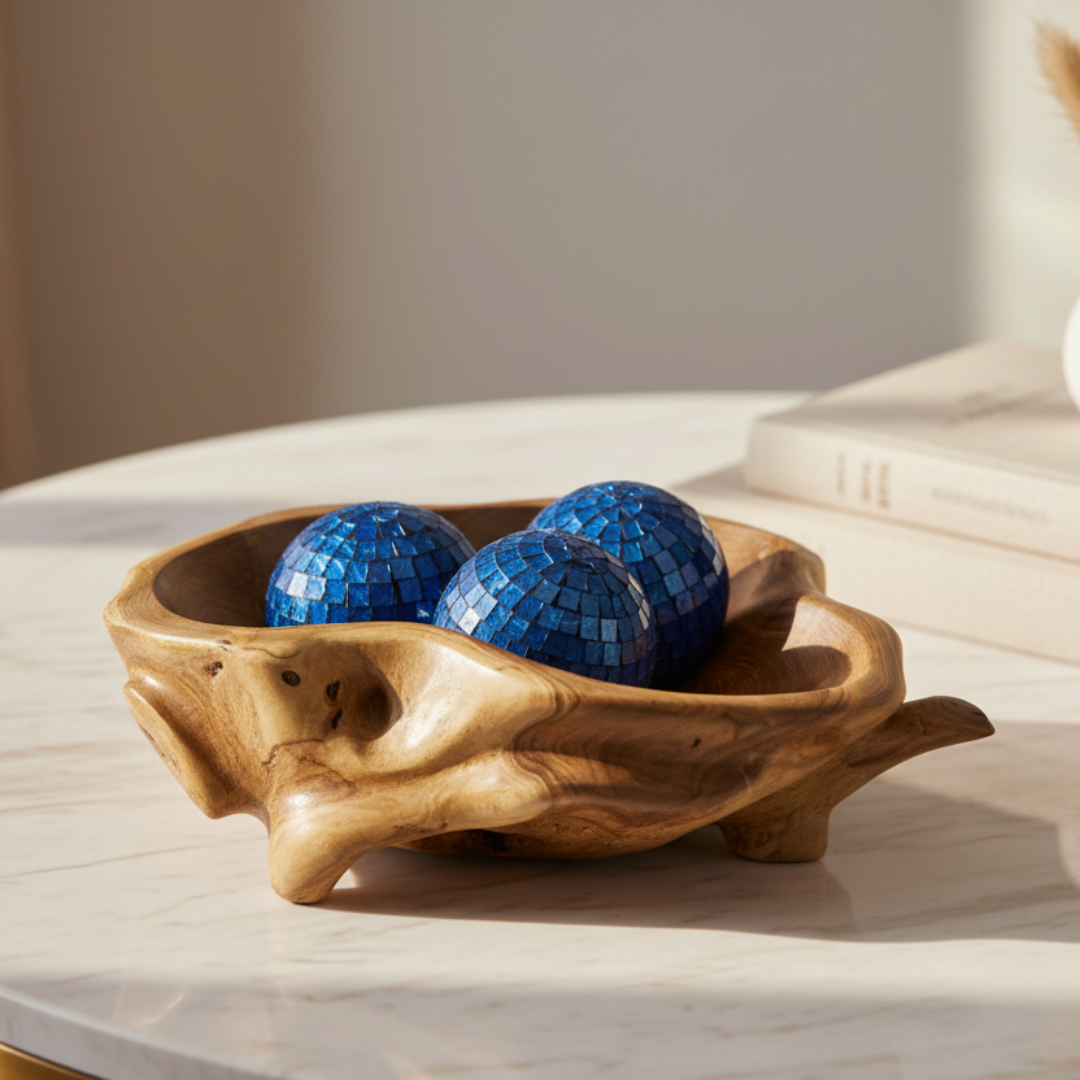 Natural Teakwood Abstract Bowl with organic free-form edges styled on a white marble table with three blue mosaic decorative balls, warm natural light and neutral linen backdrop