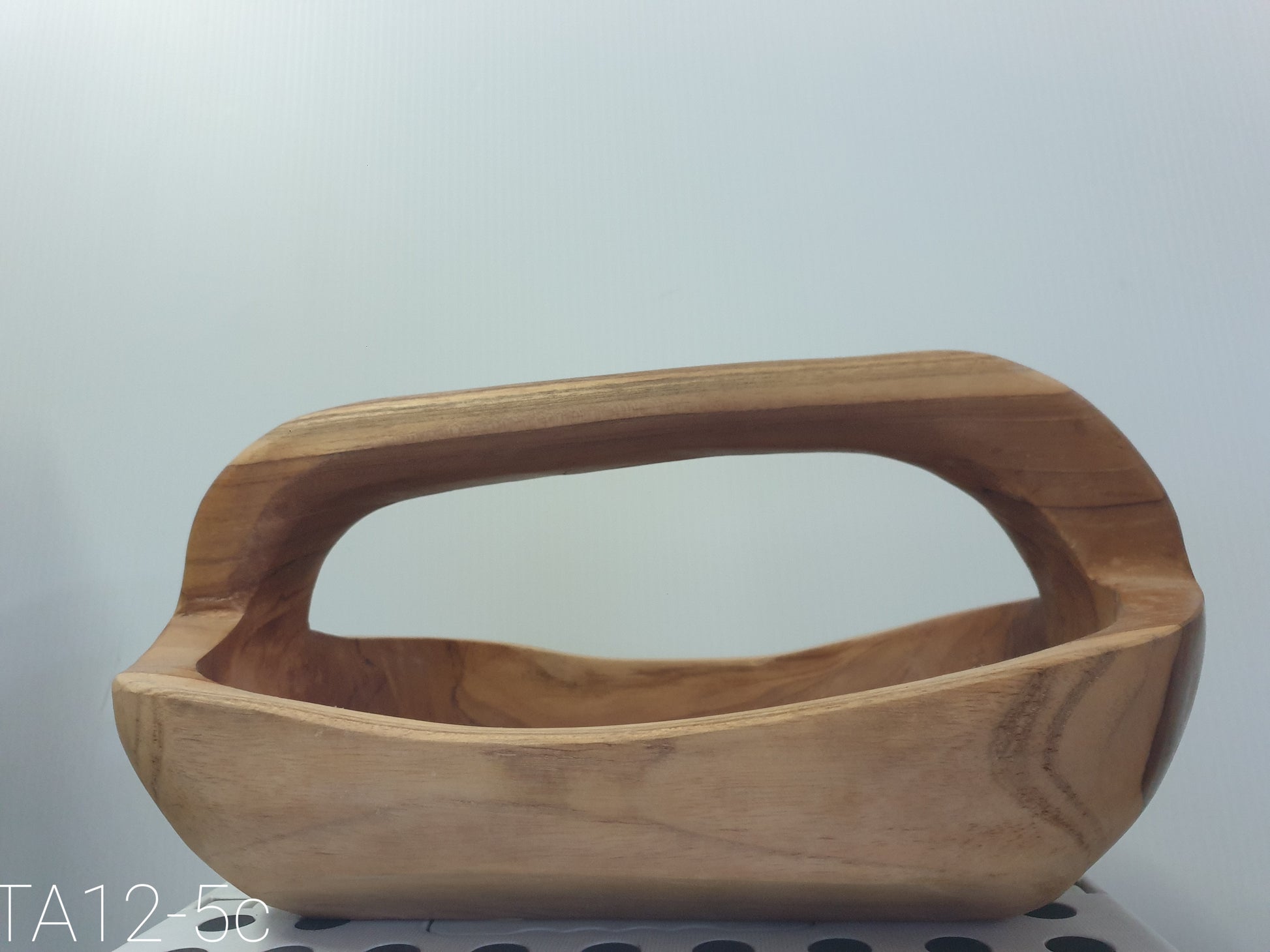 natural wooden bowl with a handle solid wood design on a gray wall 