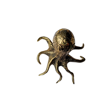 Side view of a solid brass octopus figurine showing detailed tentacle texture and warm antique gold tone, on a white background