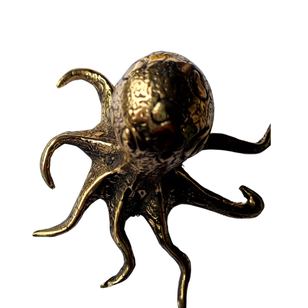 Side view of a solid brass octopus figurine showing detailed tentacle texture and warm antique gold tone, on a white background
