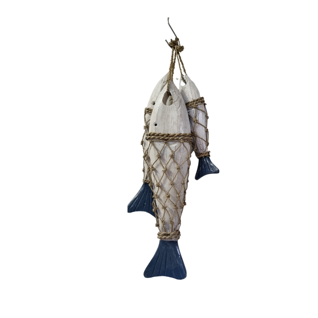 A decorative  ornament made from two white driftwood fish bodies wrapped in a natural rope net, with dark blue painted fins and tails, suspended from a metal hook against a plain white background.