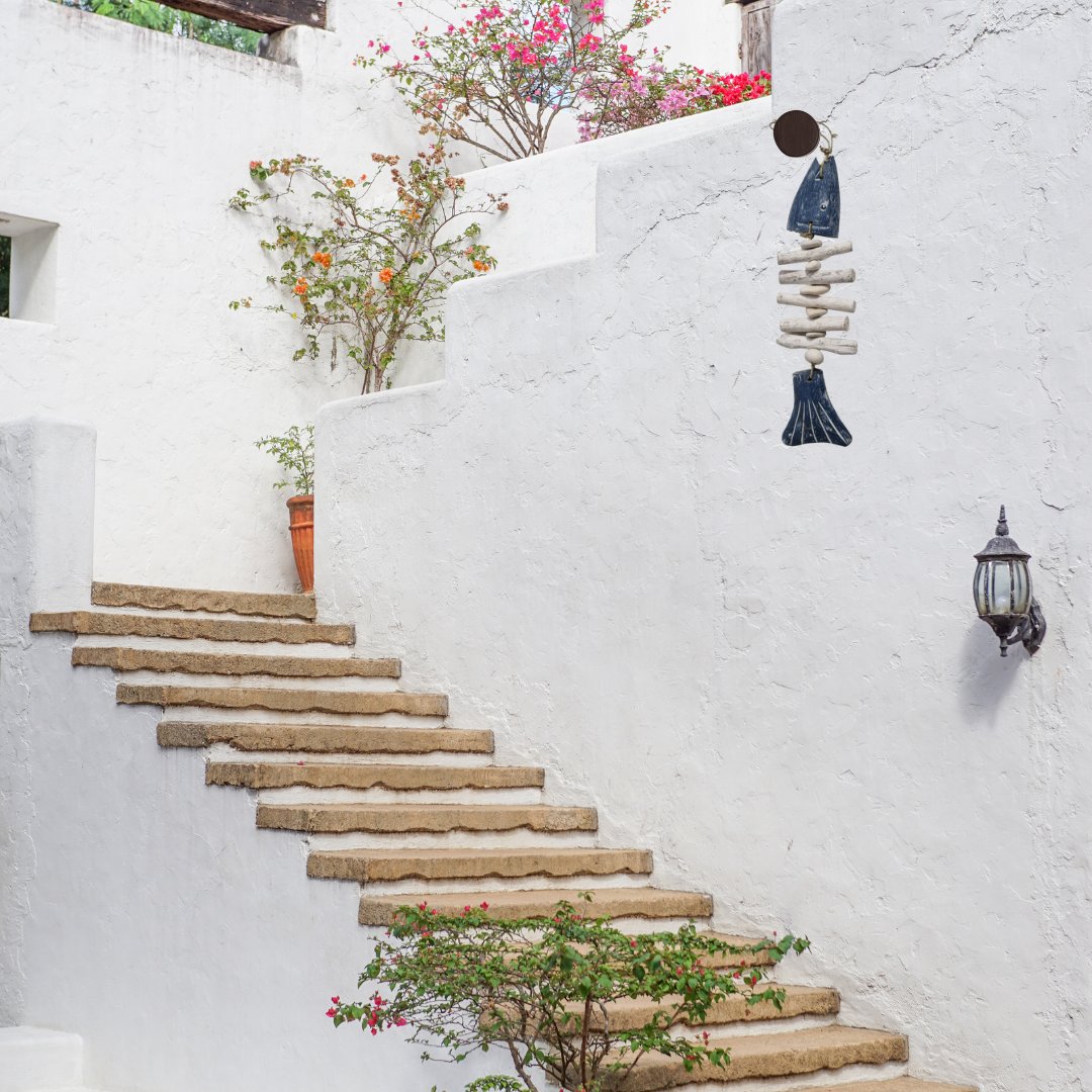 Staircase leading up a white wall with decorative elements and plants.