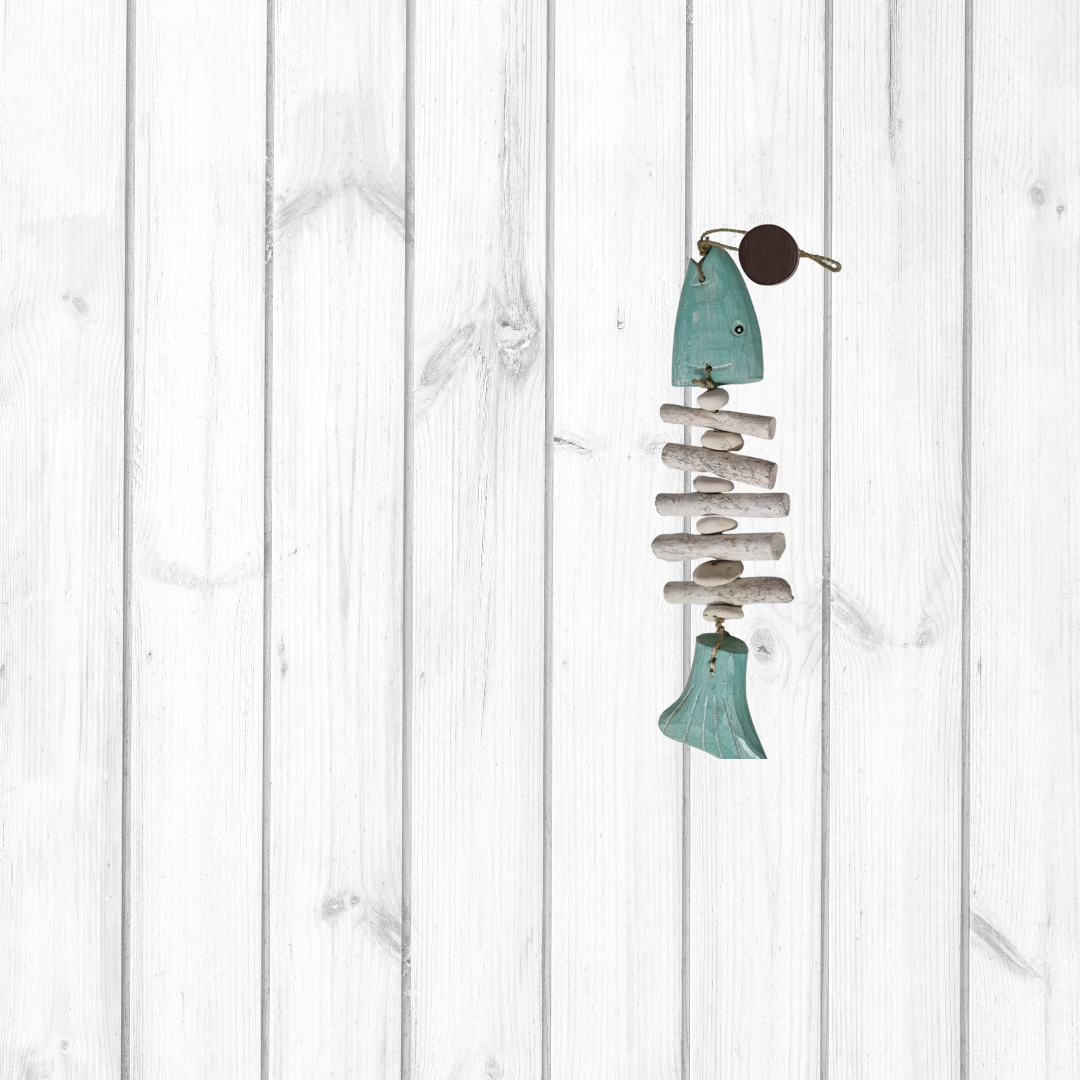 Decorative fish-shaped wind chime on a white wooden background