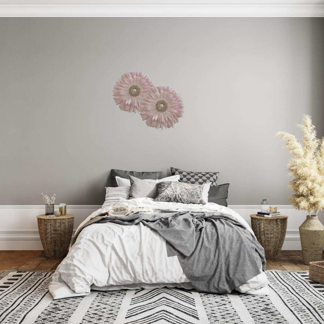 Bedroom with gray walls, a bed with gray and white bedding, and decorative elements.