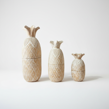 Three pineapple-shaped decorative containers in a tiered size progression, featuring a textured carved pattern and a fluted top, displayed on a clean white studio background.