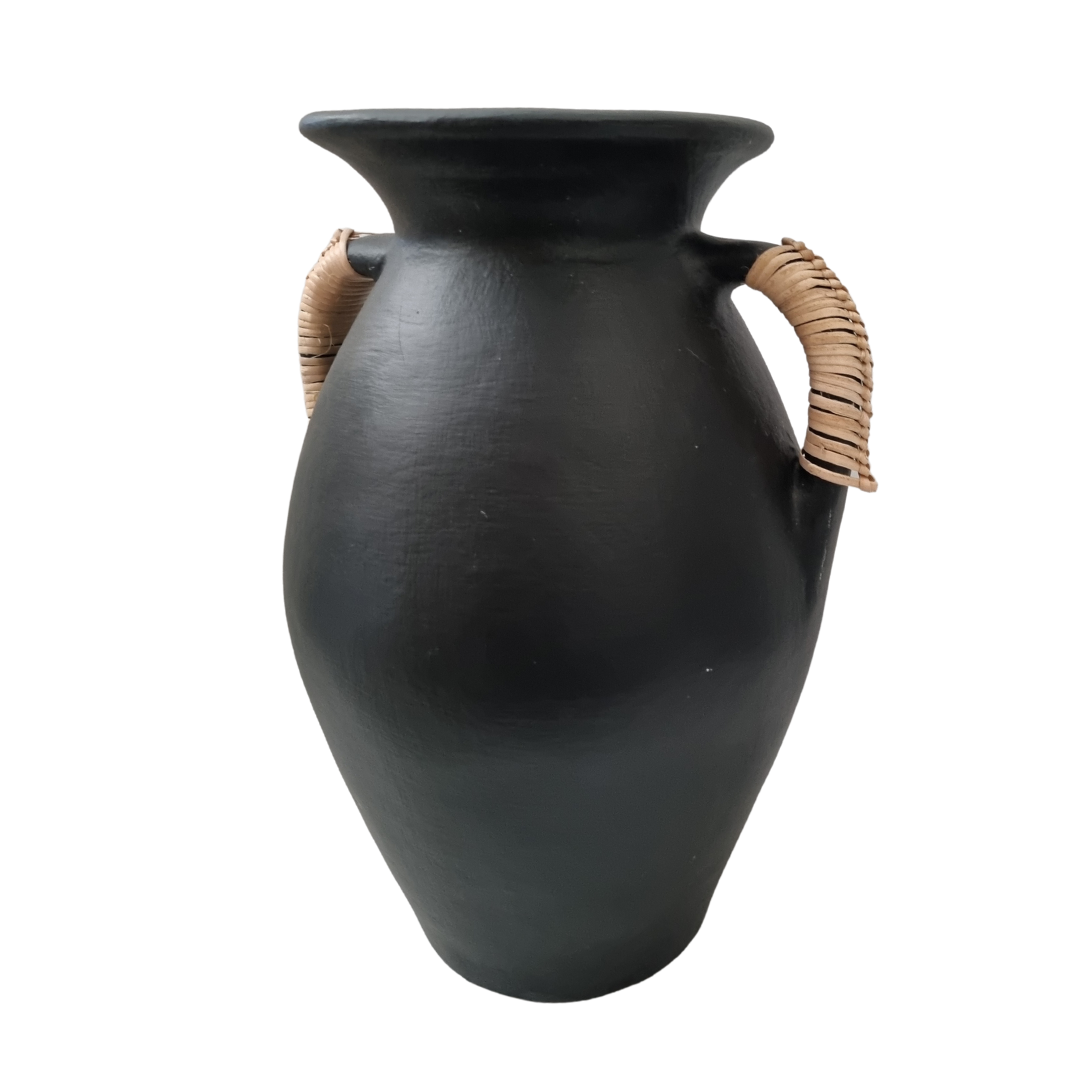 blace vase with ratton handles on a white back wall