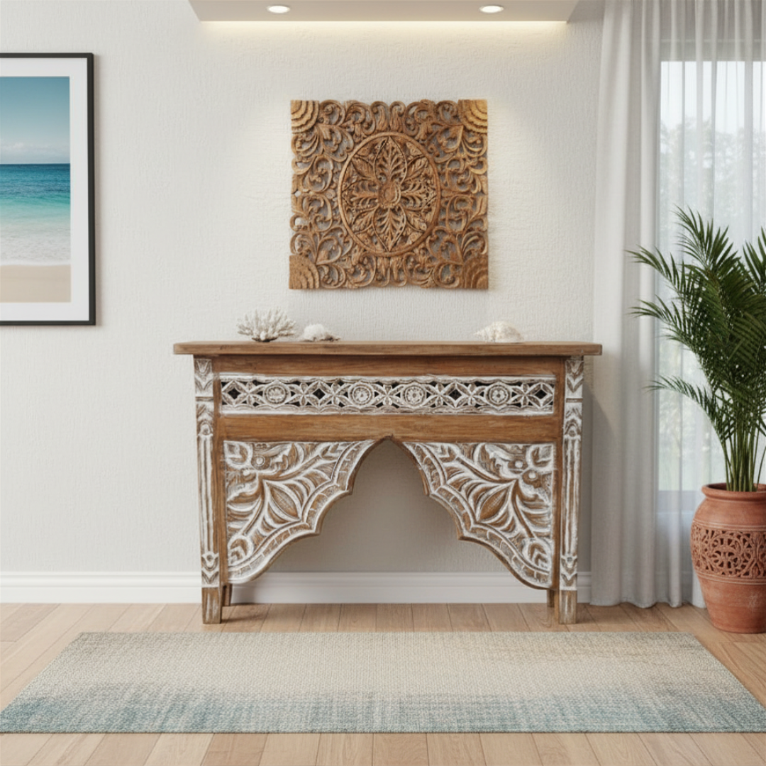 Decorative wooden console table with intricate carvings in a room with a plant and framed picture.