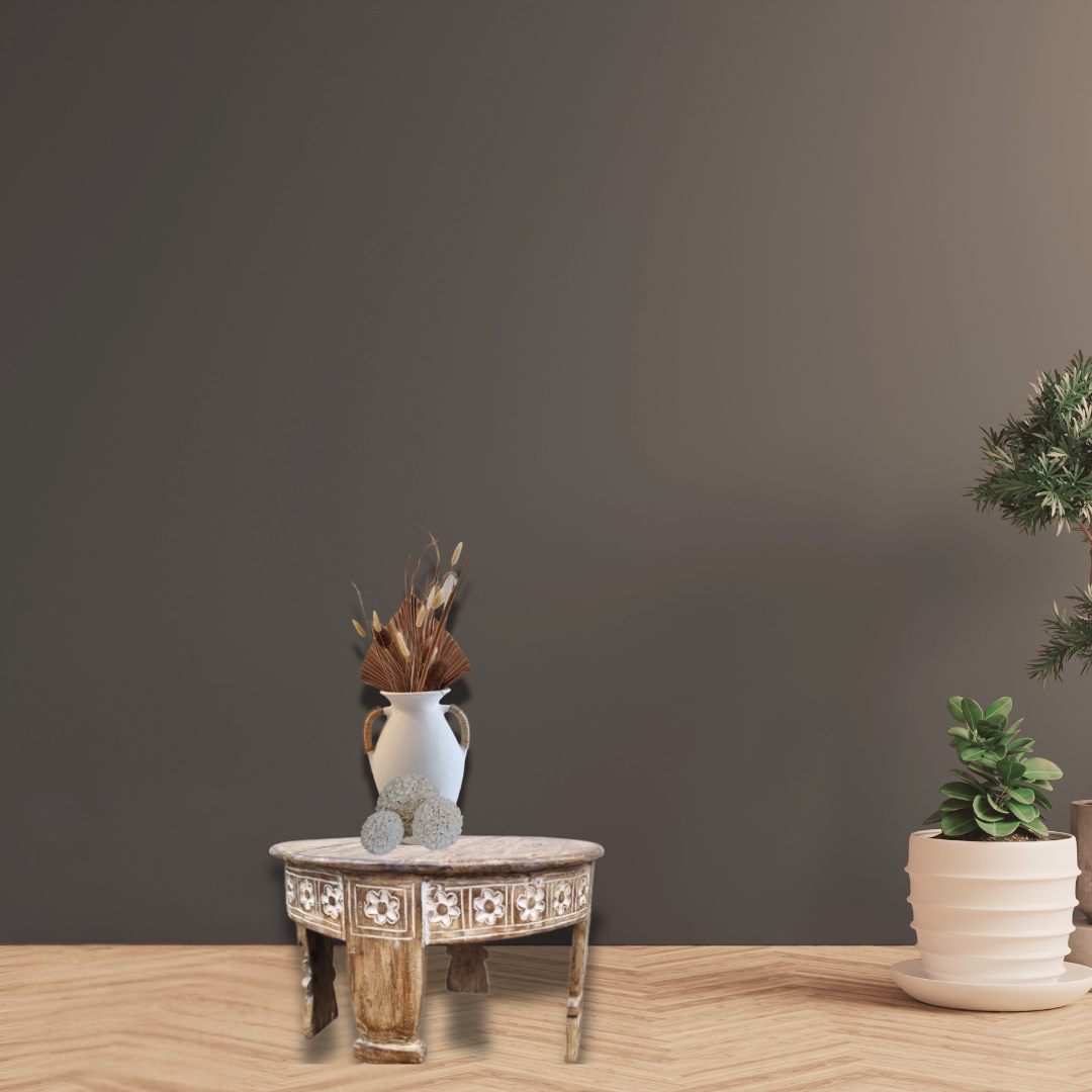 Decorative table with a vase and plants against a dark wall