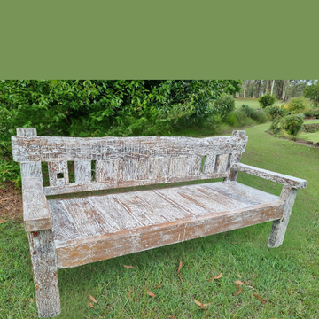 Wooden bench in a garden setting with greenery