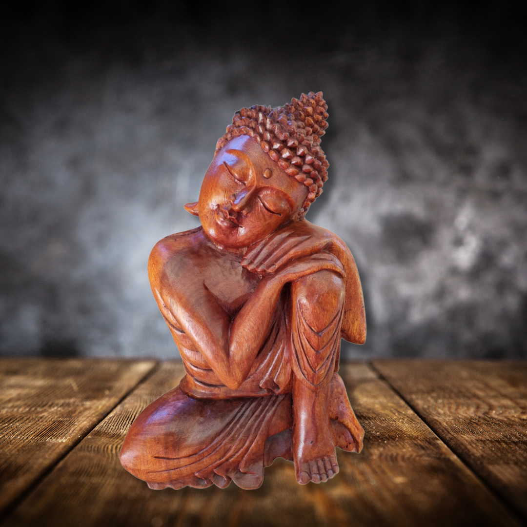 Wooden Buddha statue on a wooden surface with a dark background