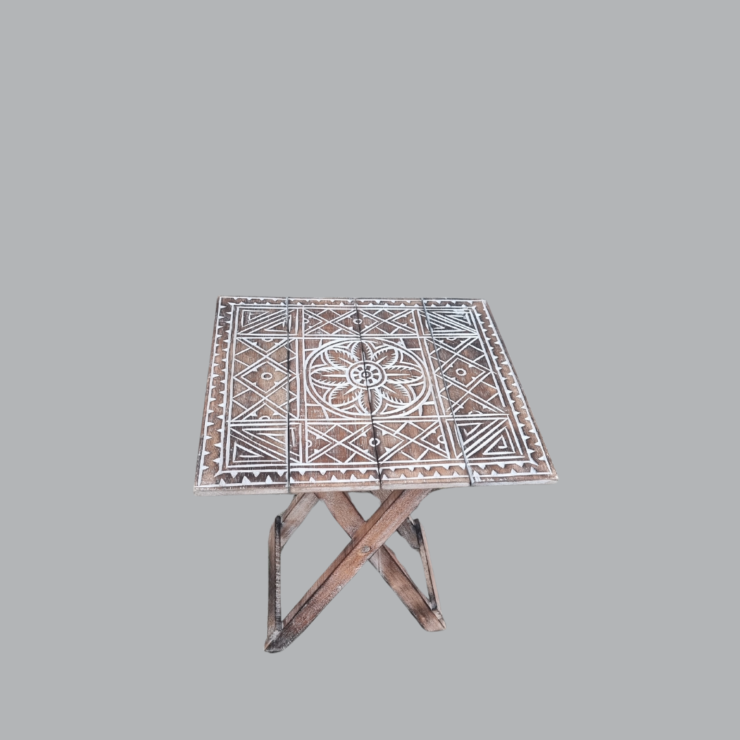 Rustic boho foldable wooden side table with hand carved geometric tribal pattern and brown wash finish, angled view showing folding cross legs, on grey background — Boho Brown Wash design 40cm x 40cm x 50cm by Azure Decor