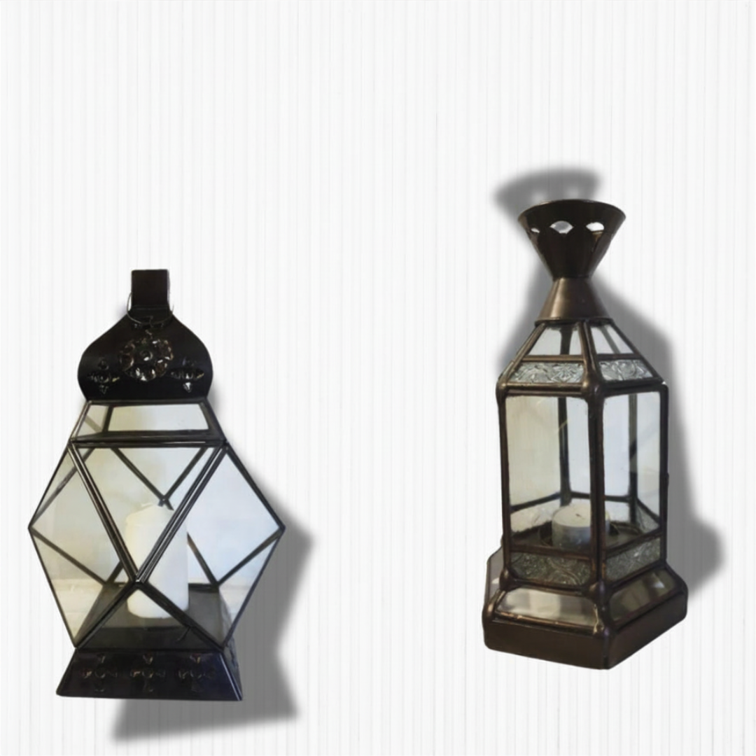 Two rustic metal lanterns side by side — Style 1 with geometric diamond-shaped glass panels and floral dome top, and Style 2 with hexagonal glass panels and ornate cone top, both in dark bronze finish on a white background
