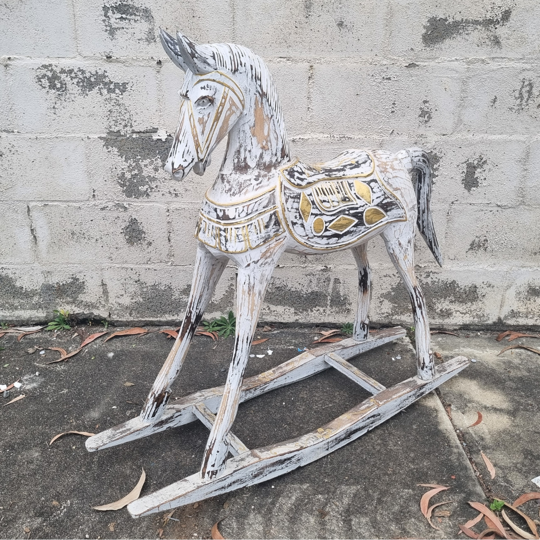 Whitewash and gold hand-carved  photographed outdoors, showing distressed paint finish and detailed saddle carvings