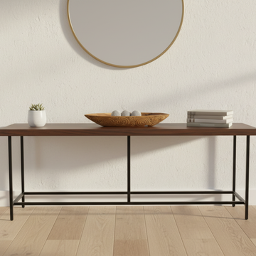 Carved teak wood boat tray styled as a centrepiece on a dark timber console table in a warm home entryway setting
