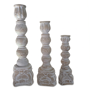 Rustic whitewashed candle holders set of three, arranged from smallest to tallest on a white background with soft shadows beneath the carved bases.