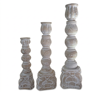 Rustic whitewashed candle holders set of three, arranged from smallest to tallest on a white background with soft shadows beneath the carved bases.