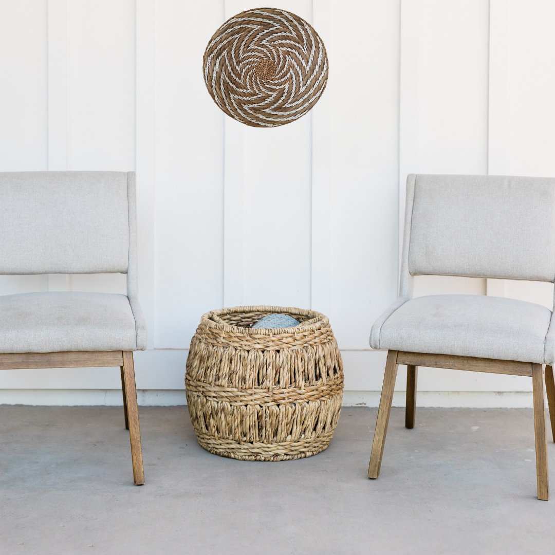 Woven basket and ottoman on a concrete floor with a white wall background