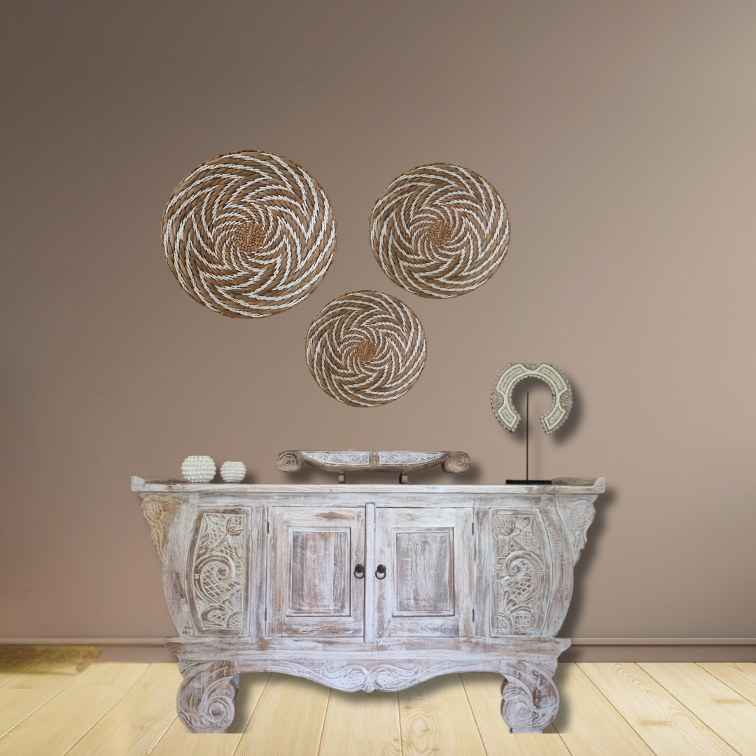 Decorative wall art with circular patterns above a wooden cabinet against a beige wall.