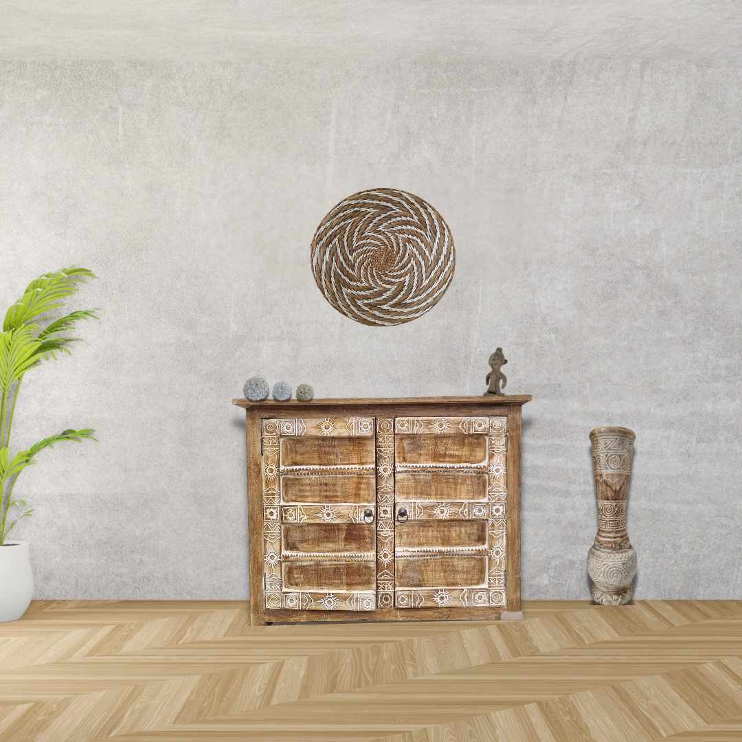 Wooden sideboard with decorative items against a gray wall.