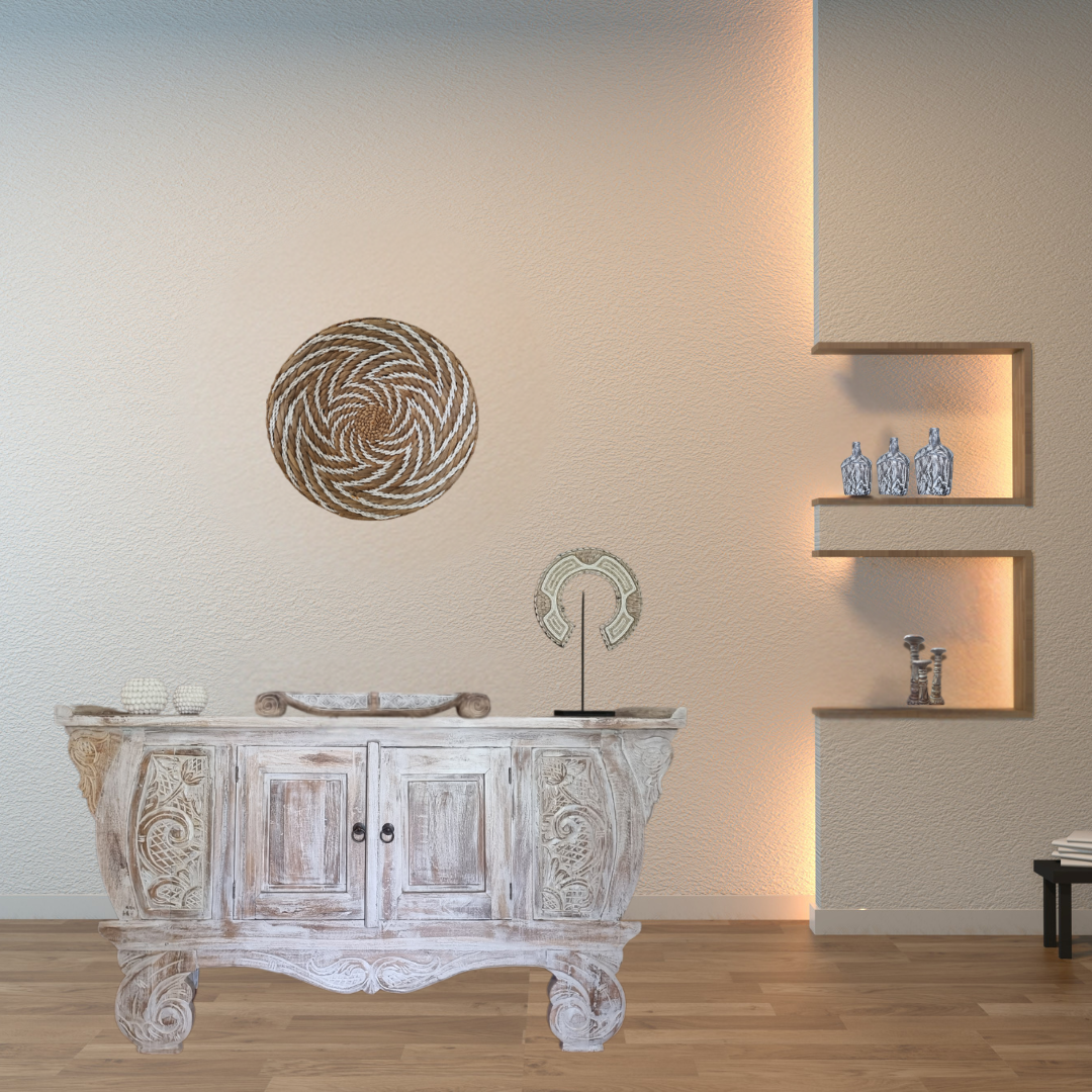 Decorative wooden cabinet with intricate carvings in a room with a wall-mounted decorative item and shelves.