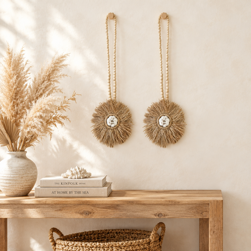 Coastal boho wall decor above a timber console with pampas and books