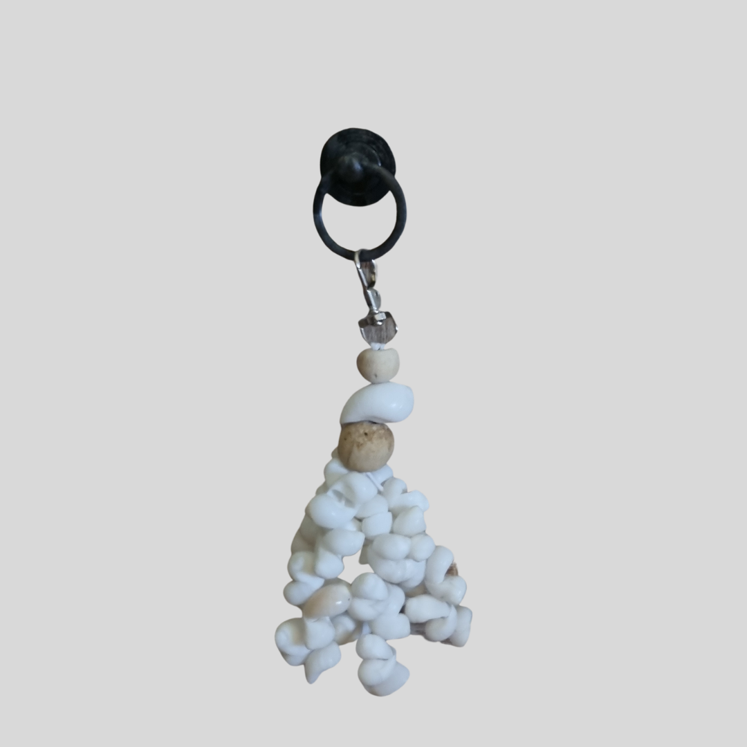 Seashell Serenity Tassel Decor hanging from a black hook, showing white shells, wooden beads and silver clip