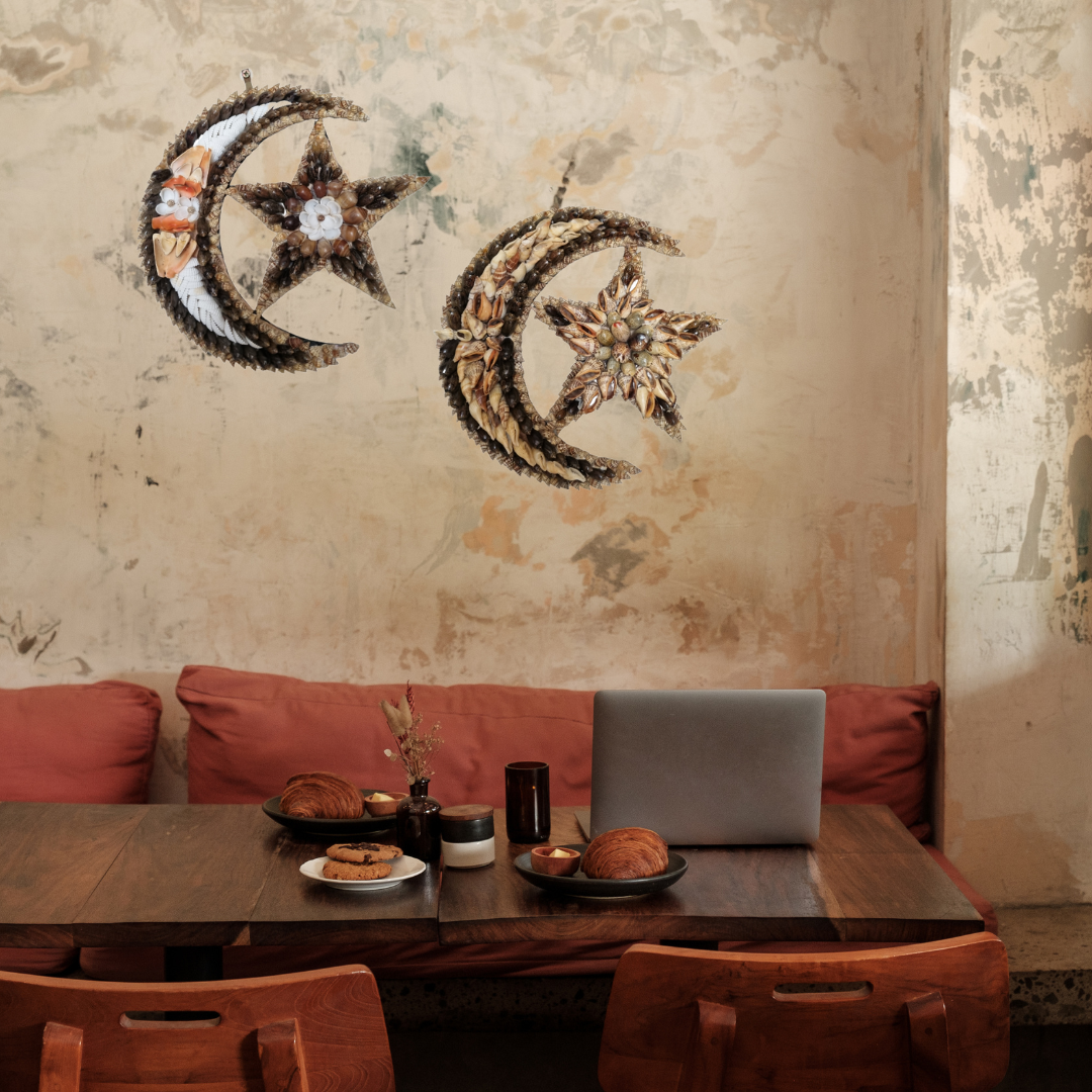 Restaurant interior with wooden table, red cushioned bench, and decorative shell wall art.
