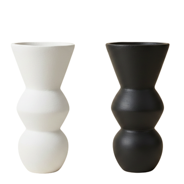 Two sculptural decorative objects side by side on a white background — one matte white, one matte black, showing both colour options