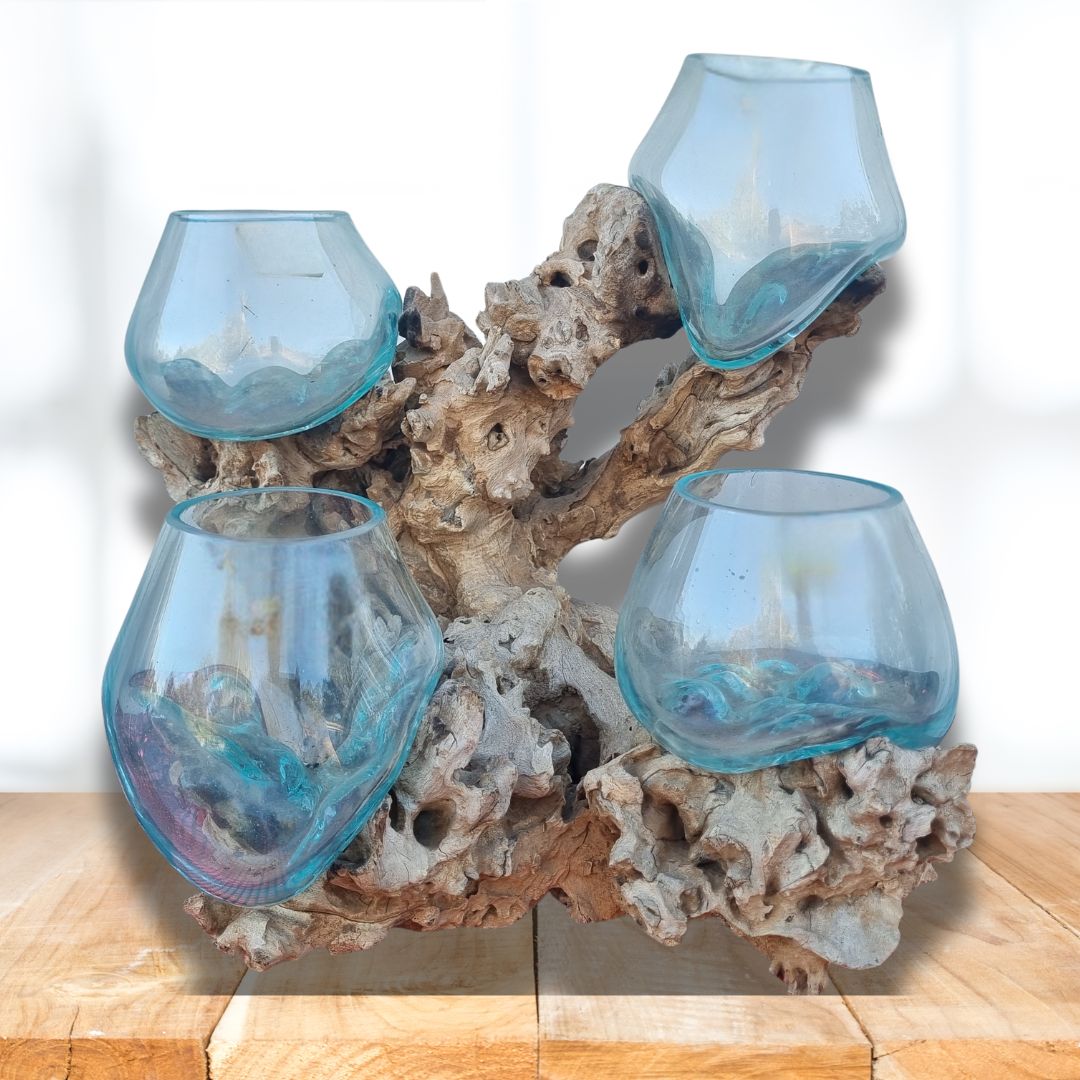 Four bowl glass holders on a piece of driftwood with a white background