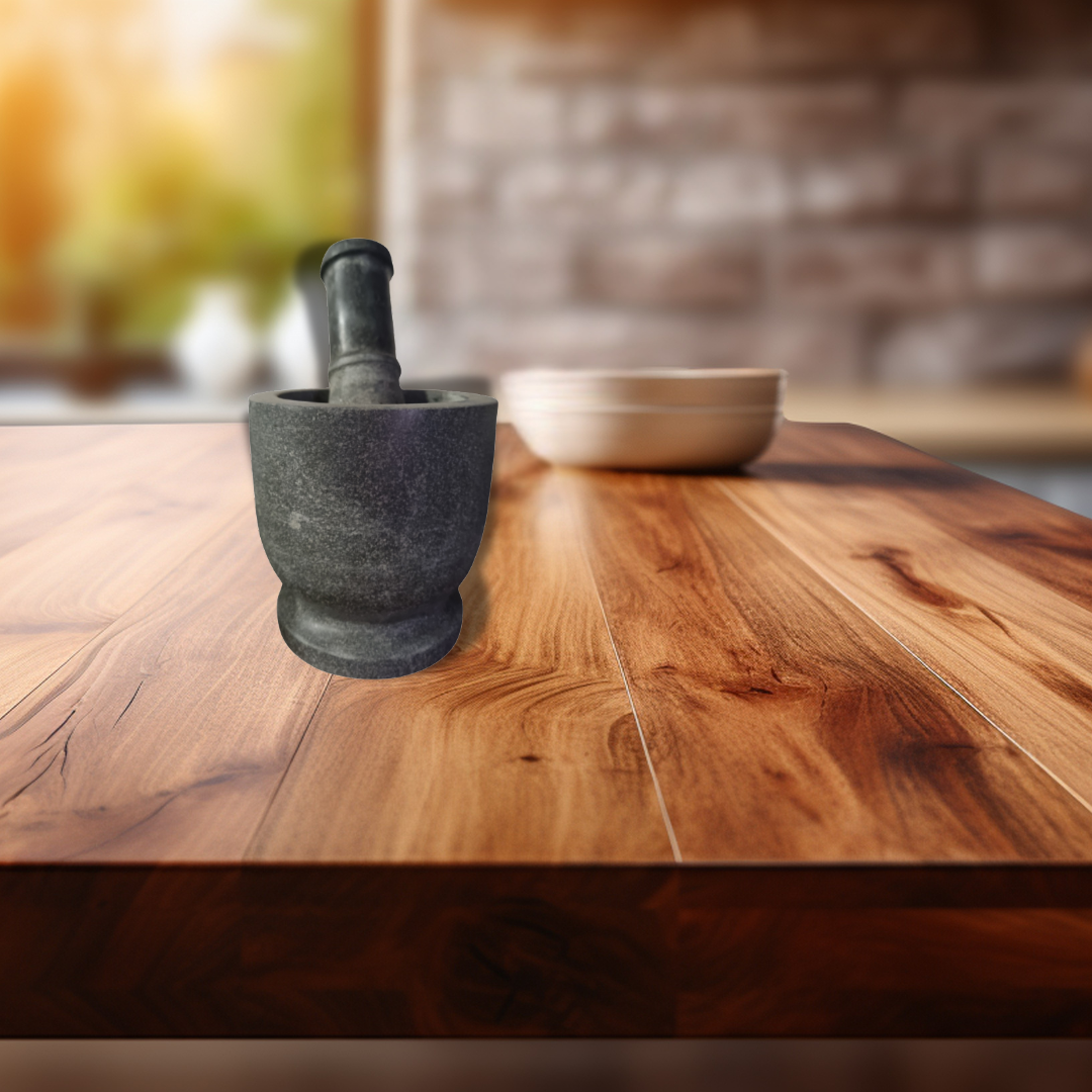 Mortar and pestle on a wooden surface with a blurred kitchen background
