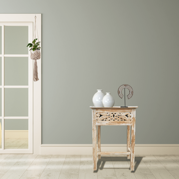 Small wooden table with decorative items against a gray wall